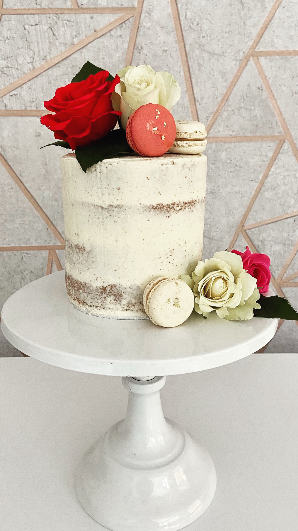 Semi-naked cake with fresh flowers and macarons